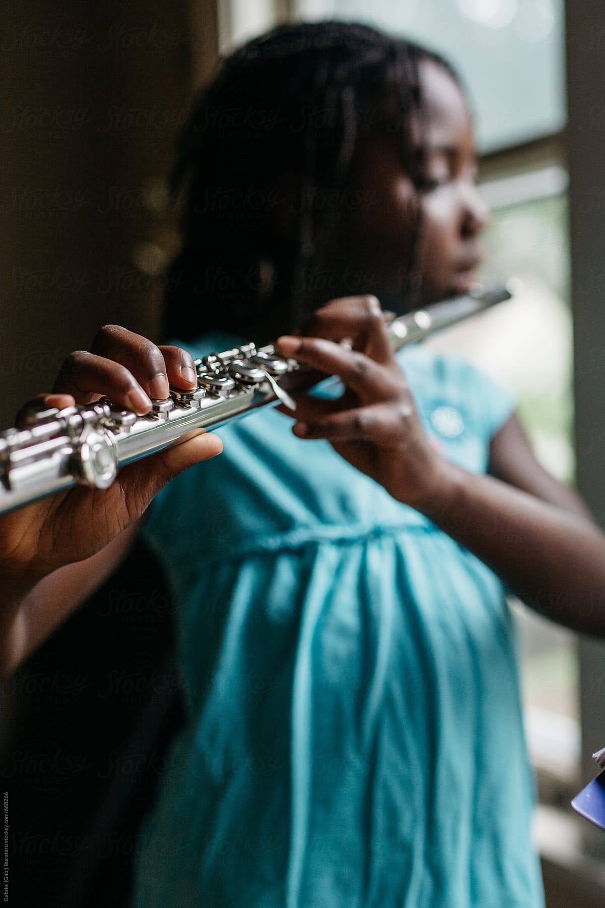 Black girl playing a flute with focus on fingers