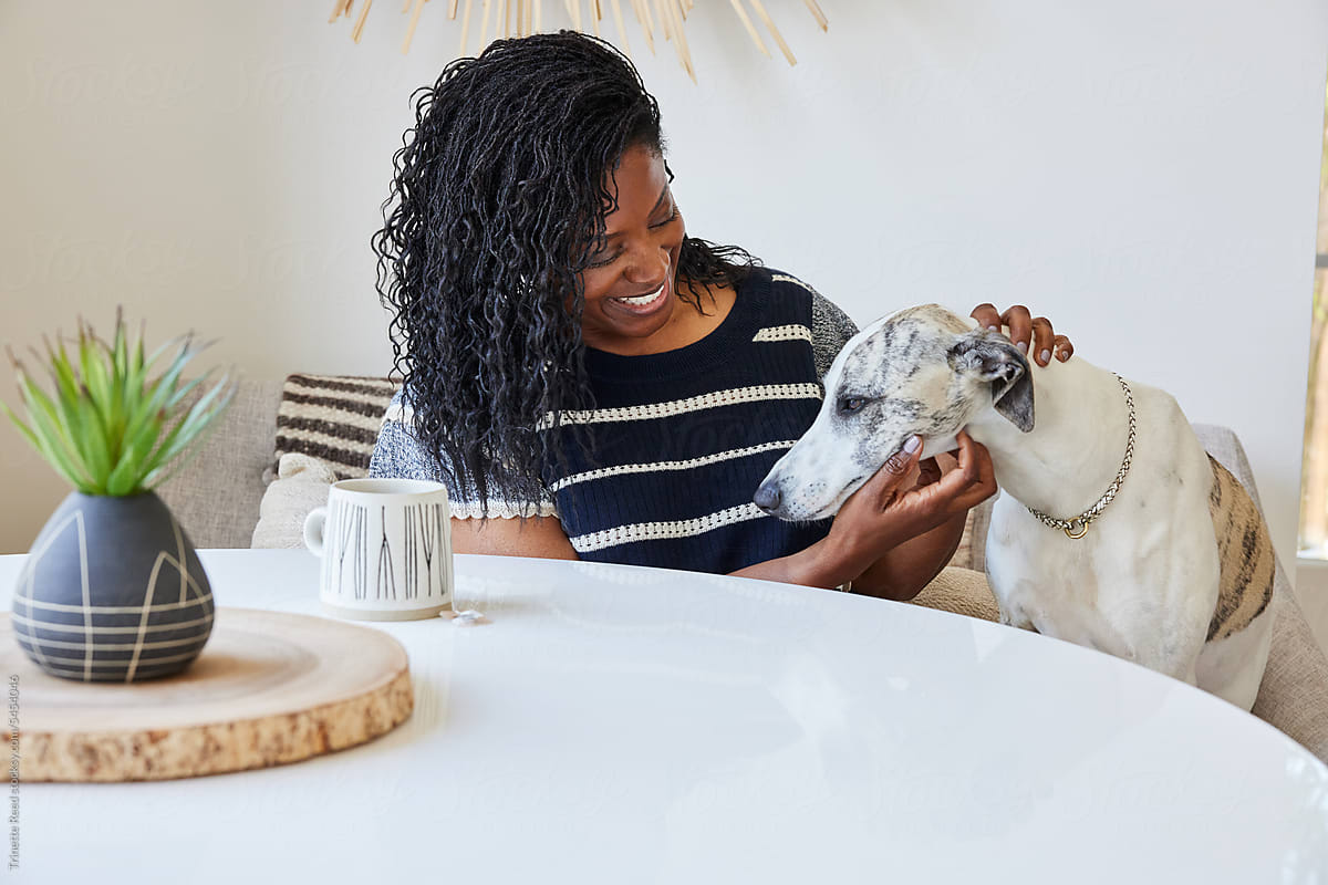Portrait of mature Black woman  at home with her pet dog