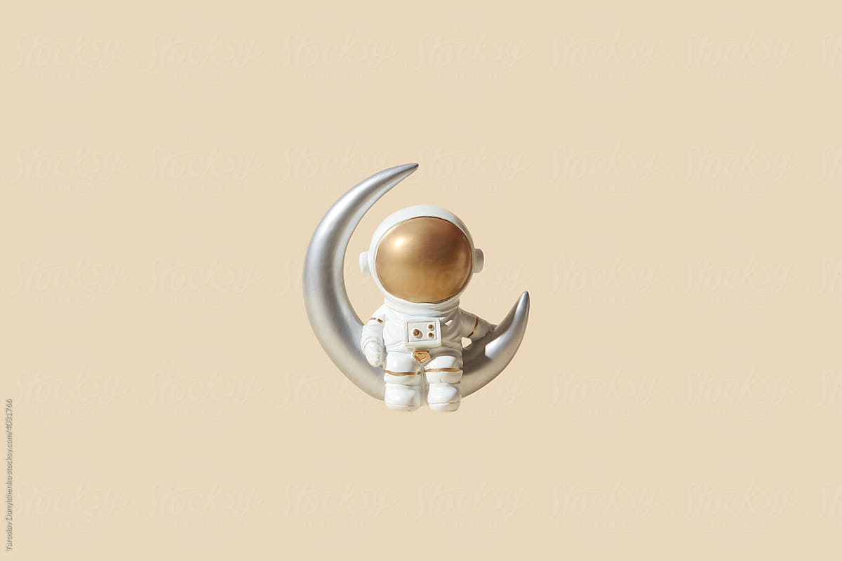 Spaceman sitting on crescent moon