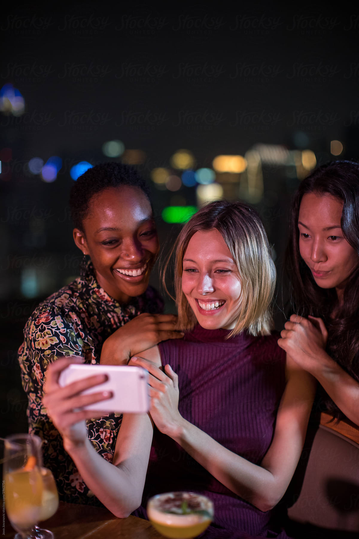 Three coworkers taking selfie together at bar