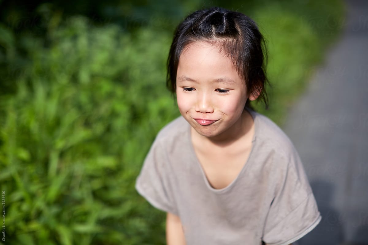 Cute Asian little girl with a naughty expression in the fields of Southeast Asian countryside