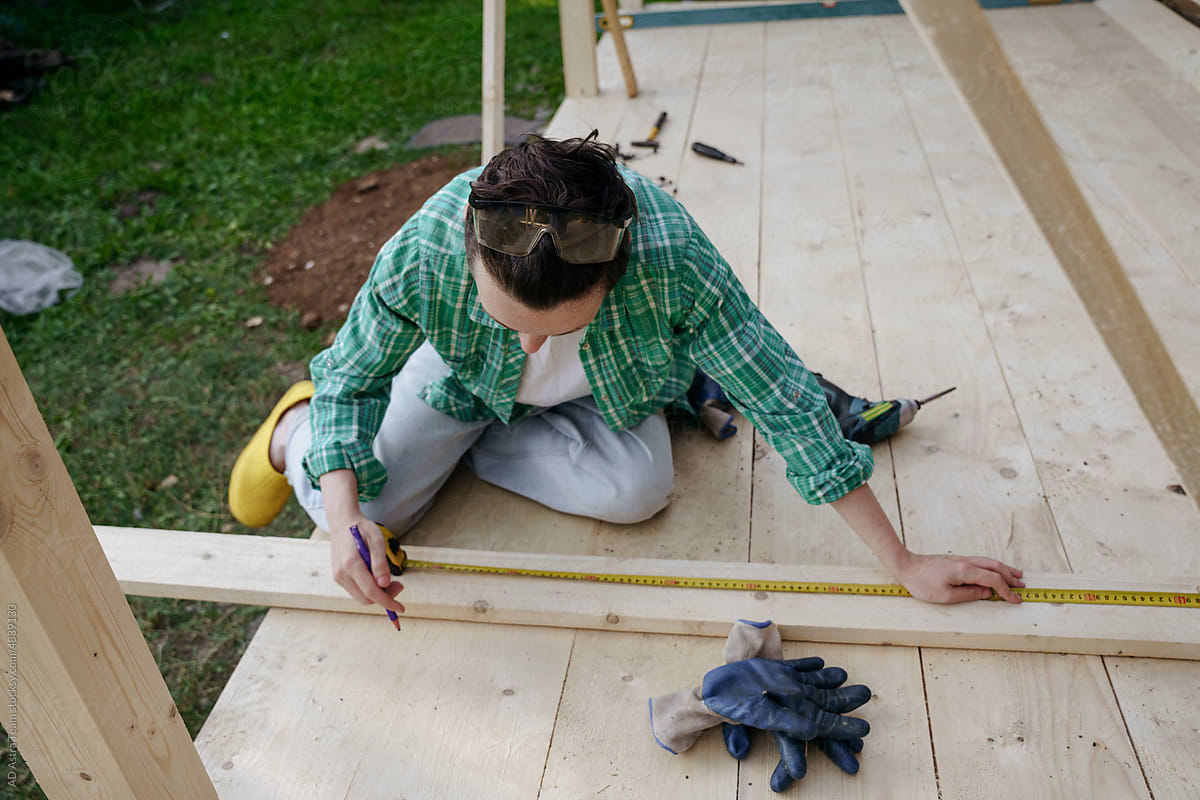 A female carpenter at work on a project in the backyard