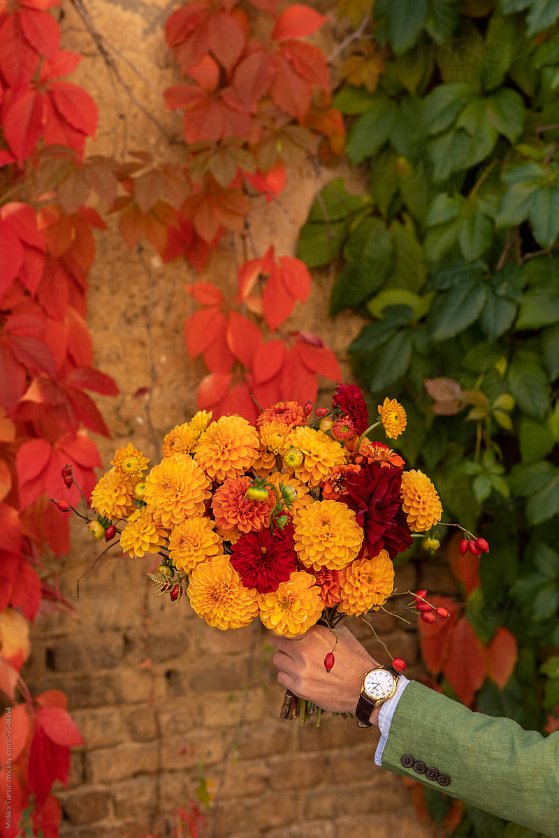 man holding autumn bouquet of flowers