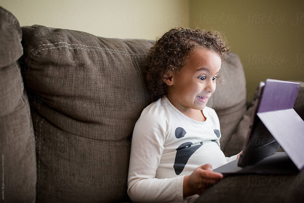 Grinning Preschooler on tablet on couch