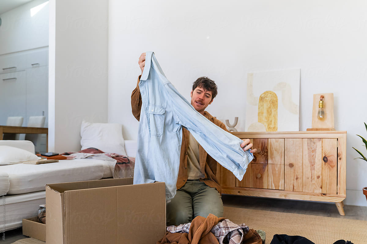 man folding clothes at home