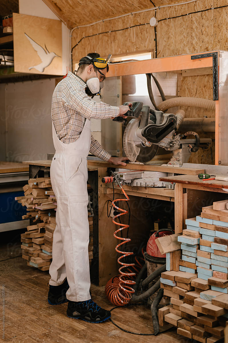 Carpenter cutting wood in workshop