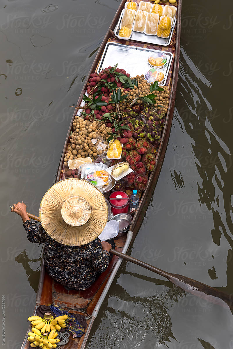 Thai seller sailing in boat full of fruits