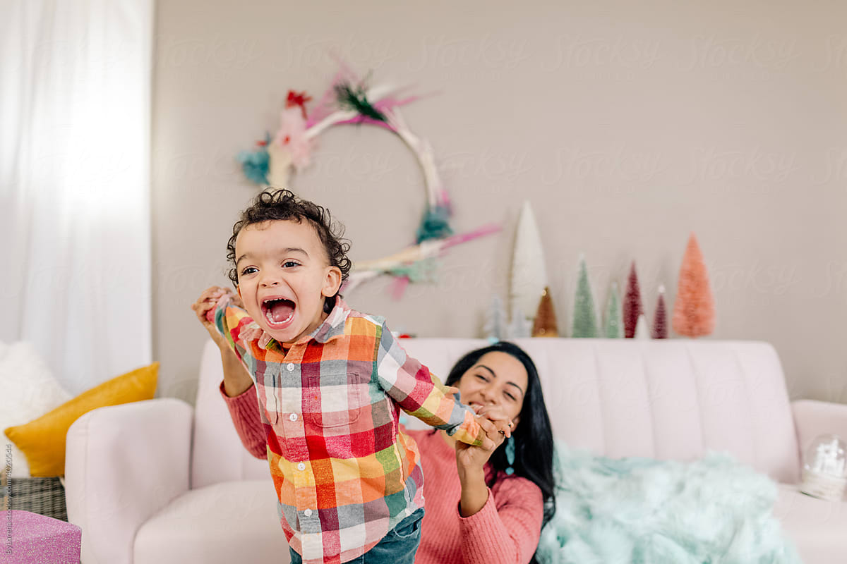 Delighted little boy playing with mother during Christmas weekend