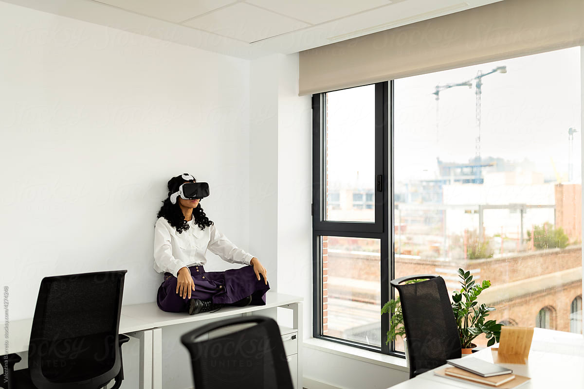 Woman using virtual reality glasses in office