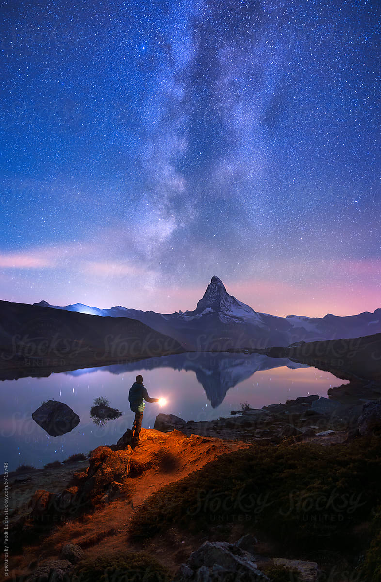 Hiker looking at the Matterhorn with a lantern