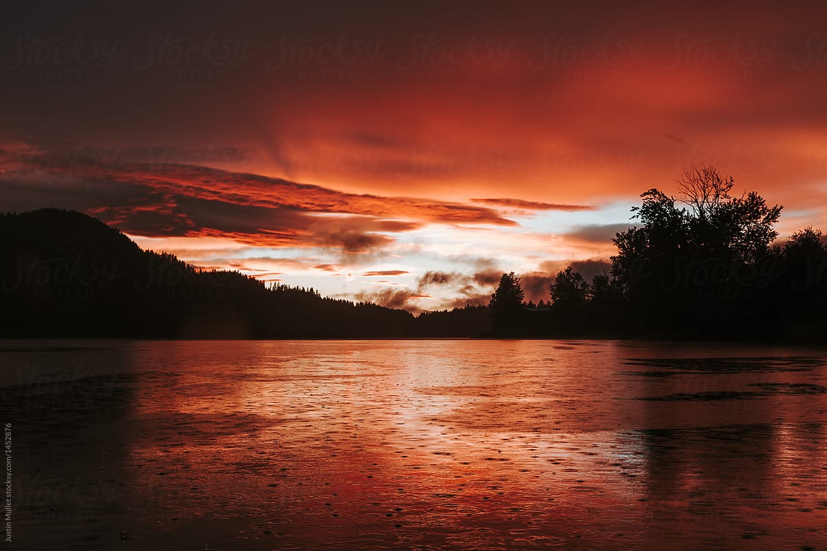 Dramatic sunset over river during a rain storm.