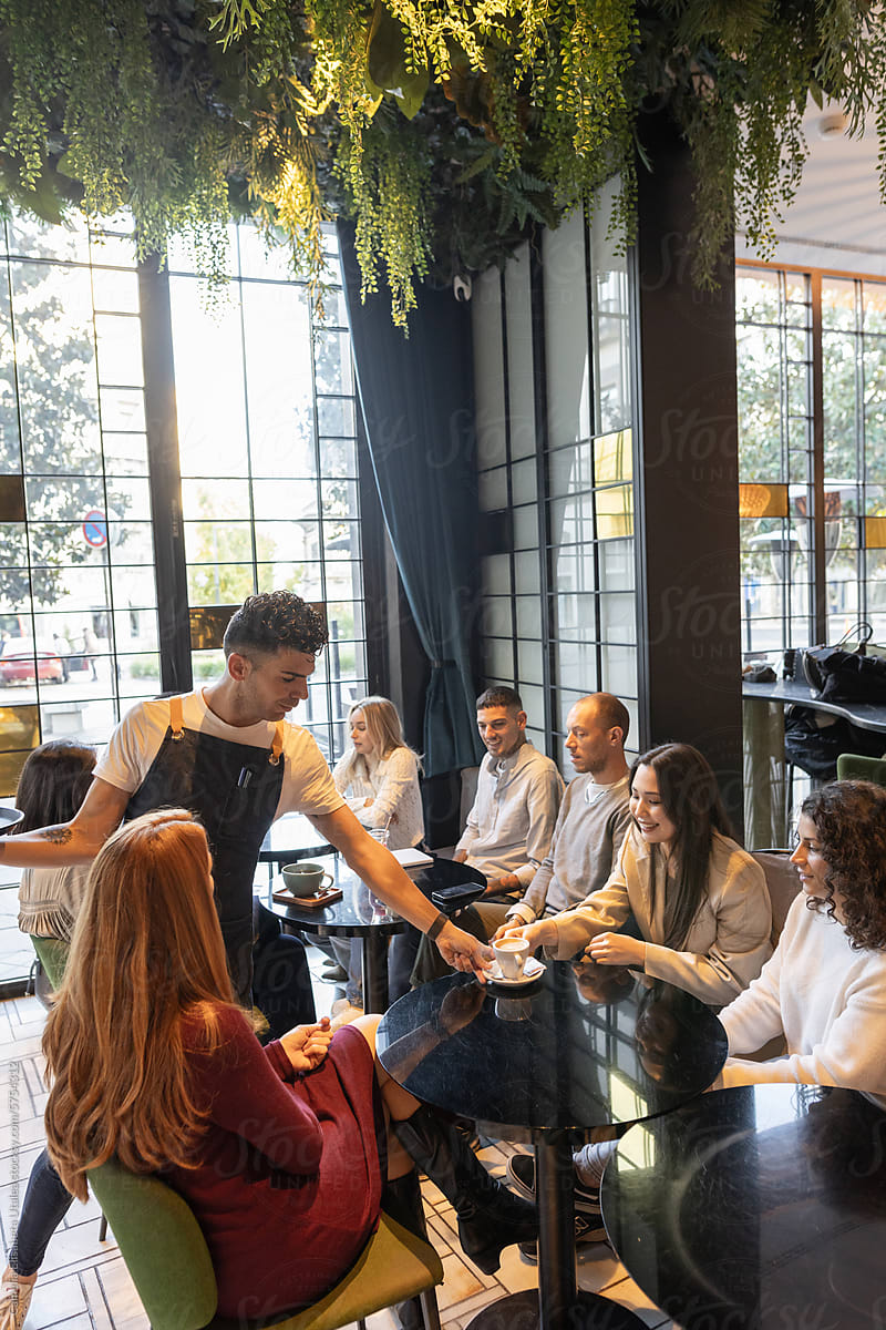 waiter serving food to a group of friends
