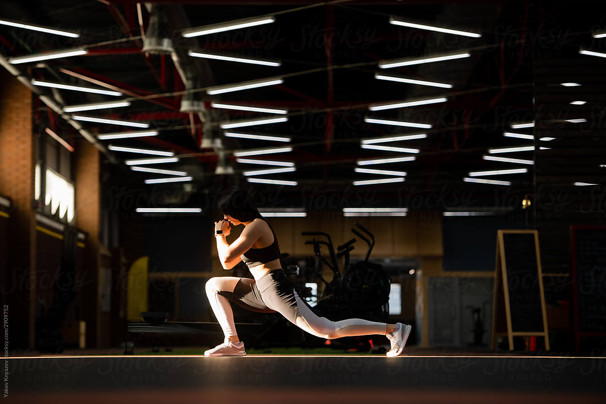 Sporty athlete girl stretching before a workout in a fancy gym