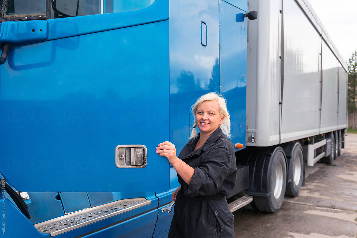 female truck driver preens ar side mirror