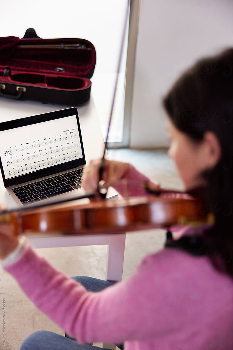 Female violinist during online lesson at home