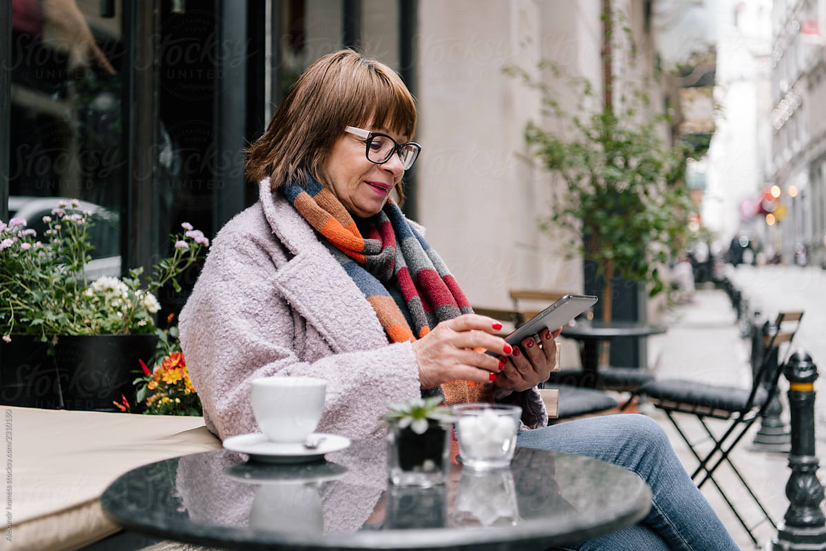 Beautiful adult woman relaxing in outdoor cafe with table