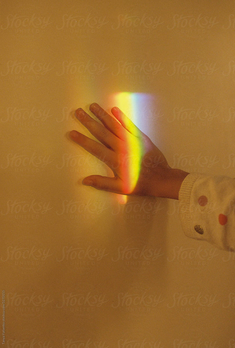 A kid\'s hand with rainbow light