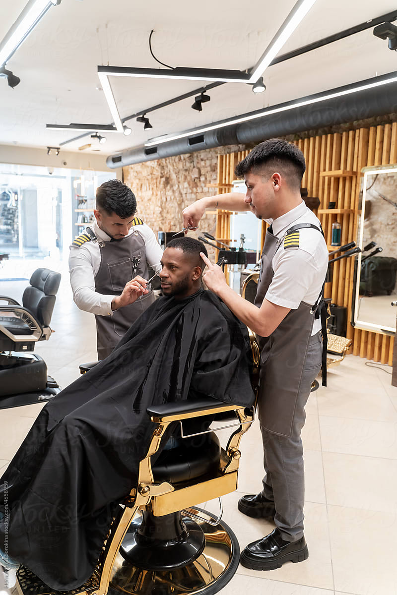 Two Barbers Working With Client
