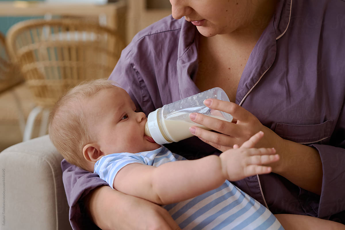 mom feeds her baby from a baby bottle