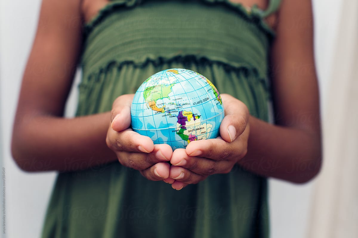 Young girl holding a globe of the world in her hands
