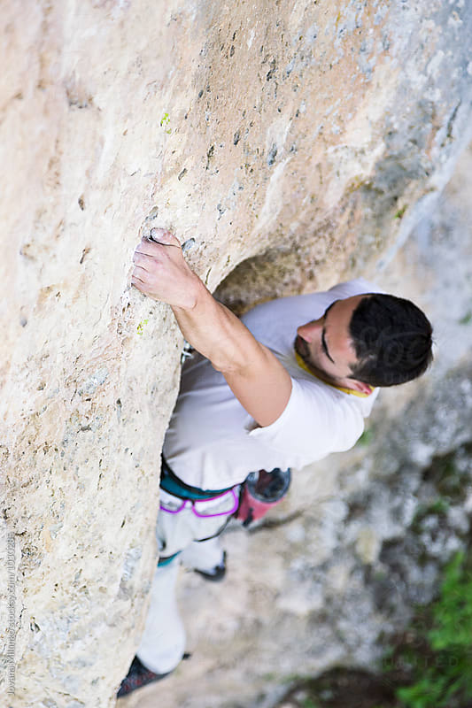 Man lead climbing vertical rout on a wall outdoors