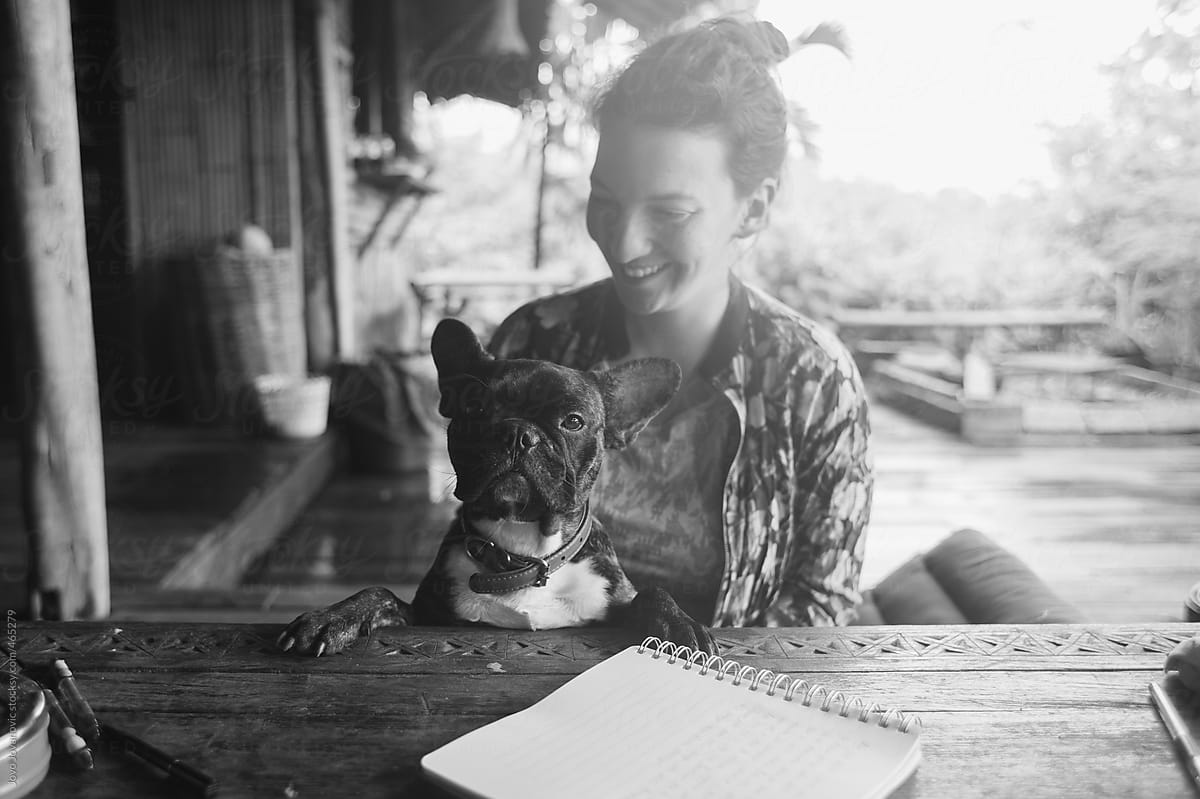 Black and white portrait of a smiling woman and a cute french bull dog