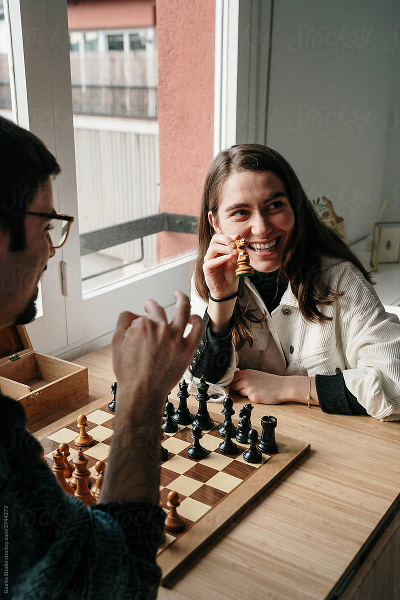 Young couple playing chess at home