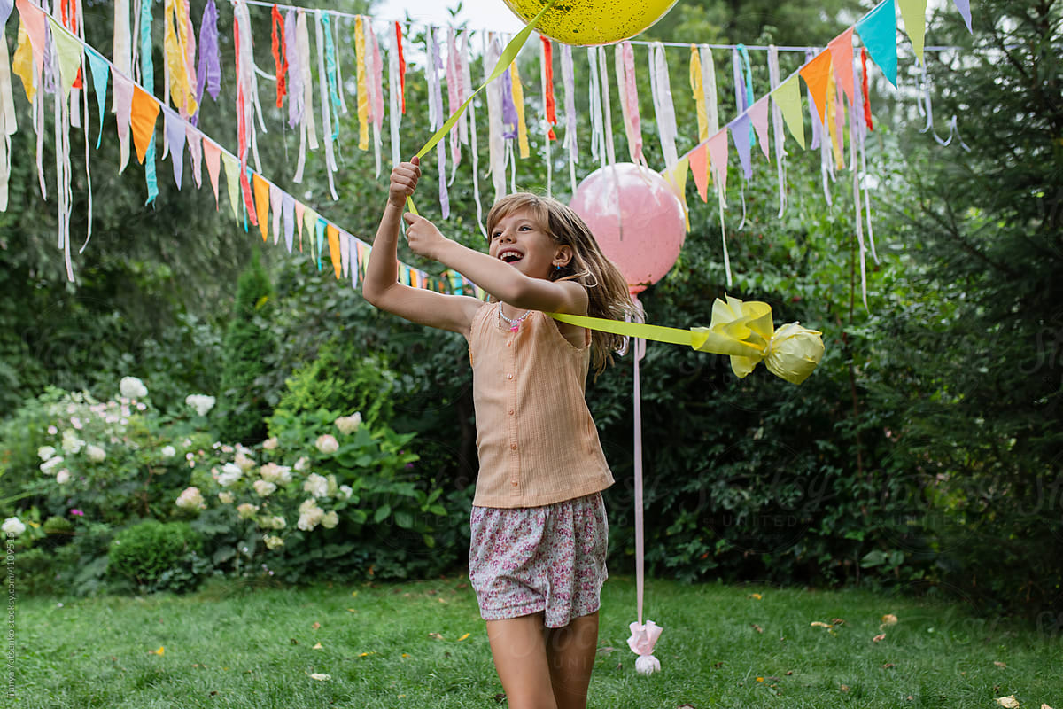 A  girl in the garden with a big balloon.