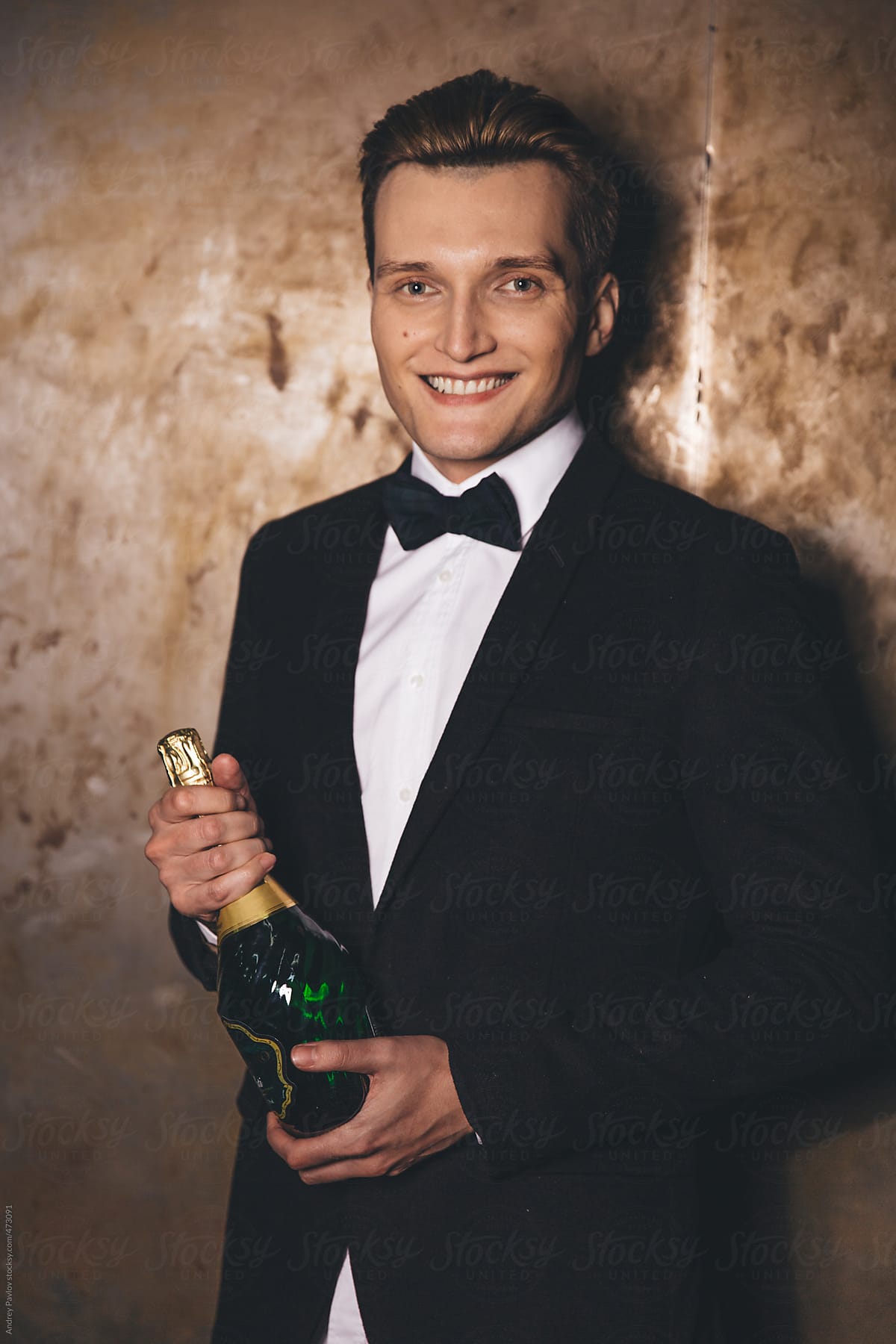 Handsome men dressed in a suit with bottle of champagne