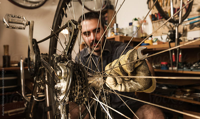 Young mechanic working on bike maintenance in his rustic workshop.