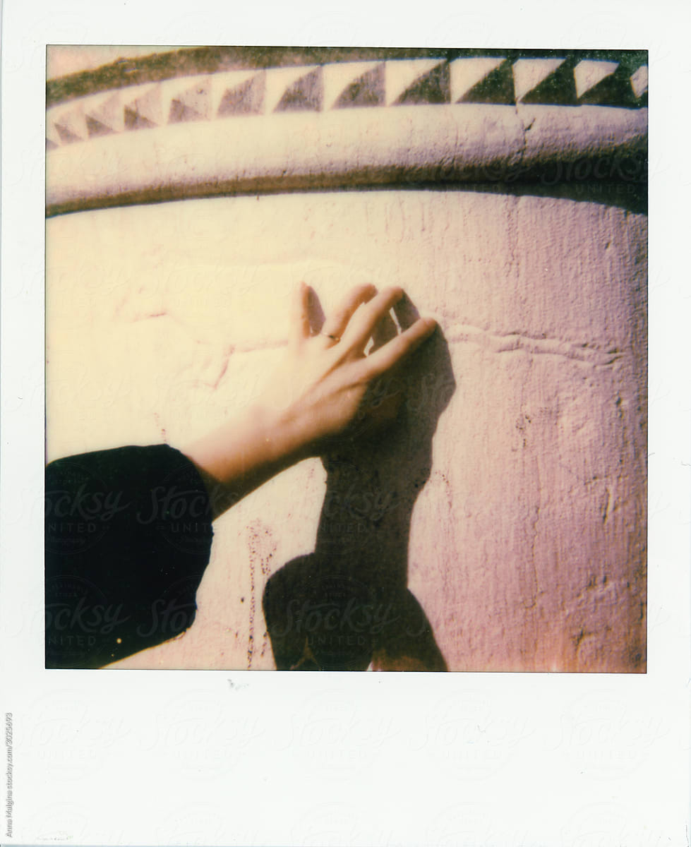 A hand touching a wall in Venice