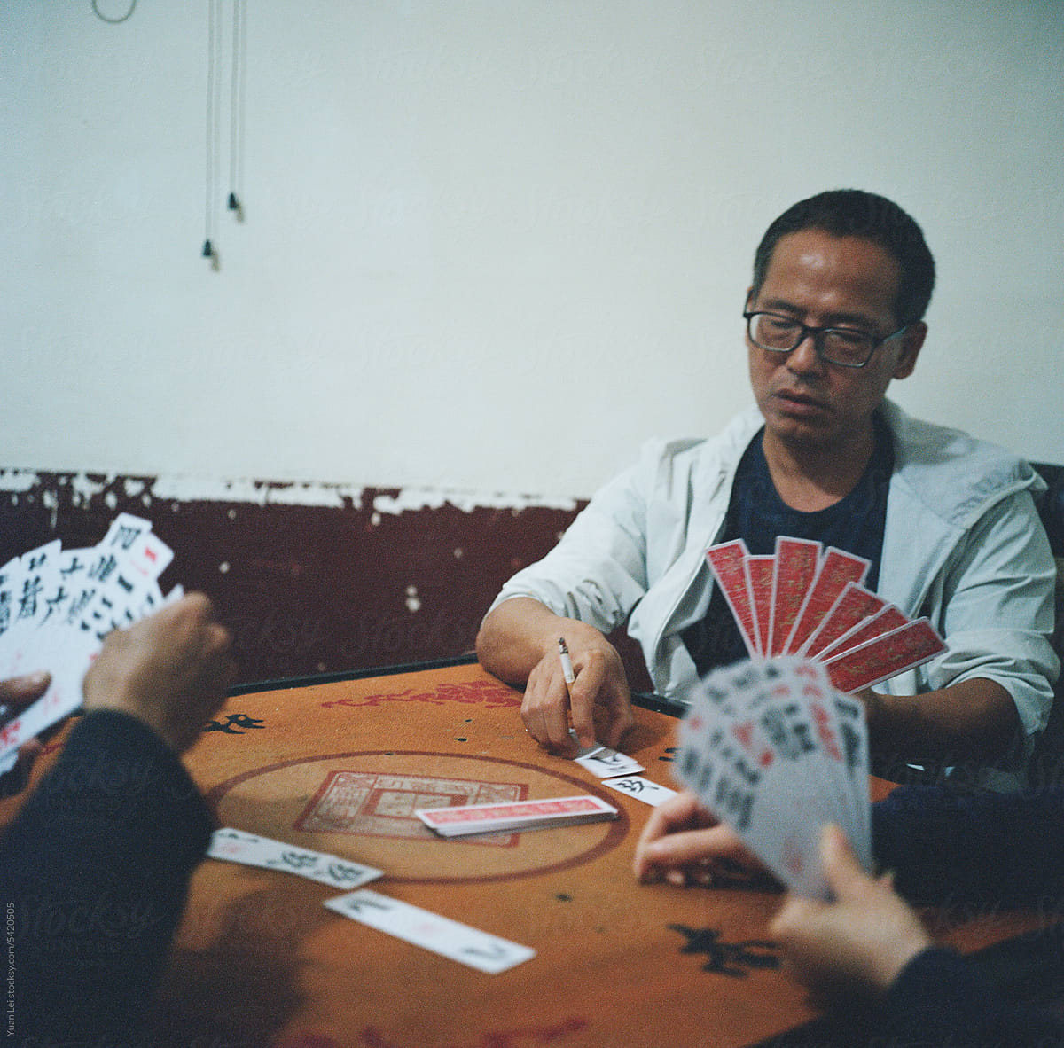 Three people are playing a Chinese poker called \