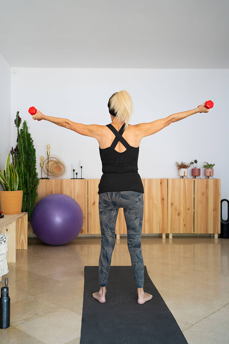 Senior woman exercising arms with dumbbells