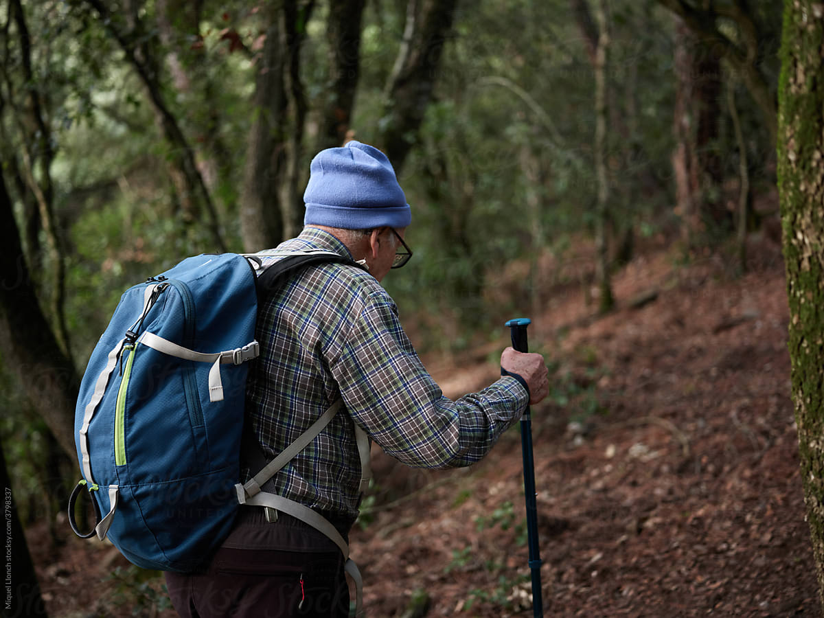 Aged man hiking into the woods