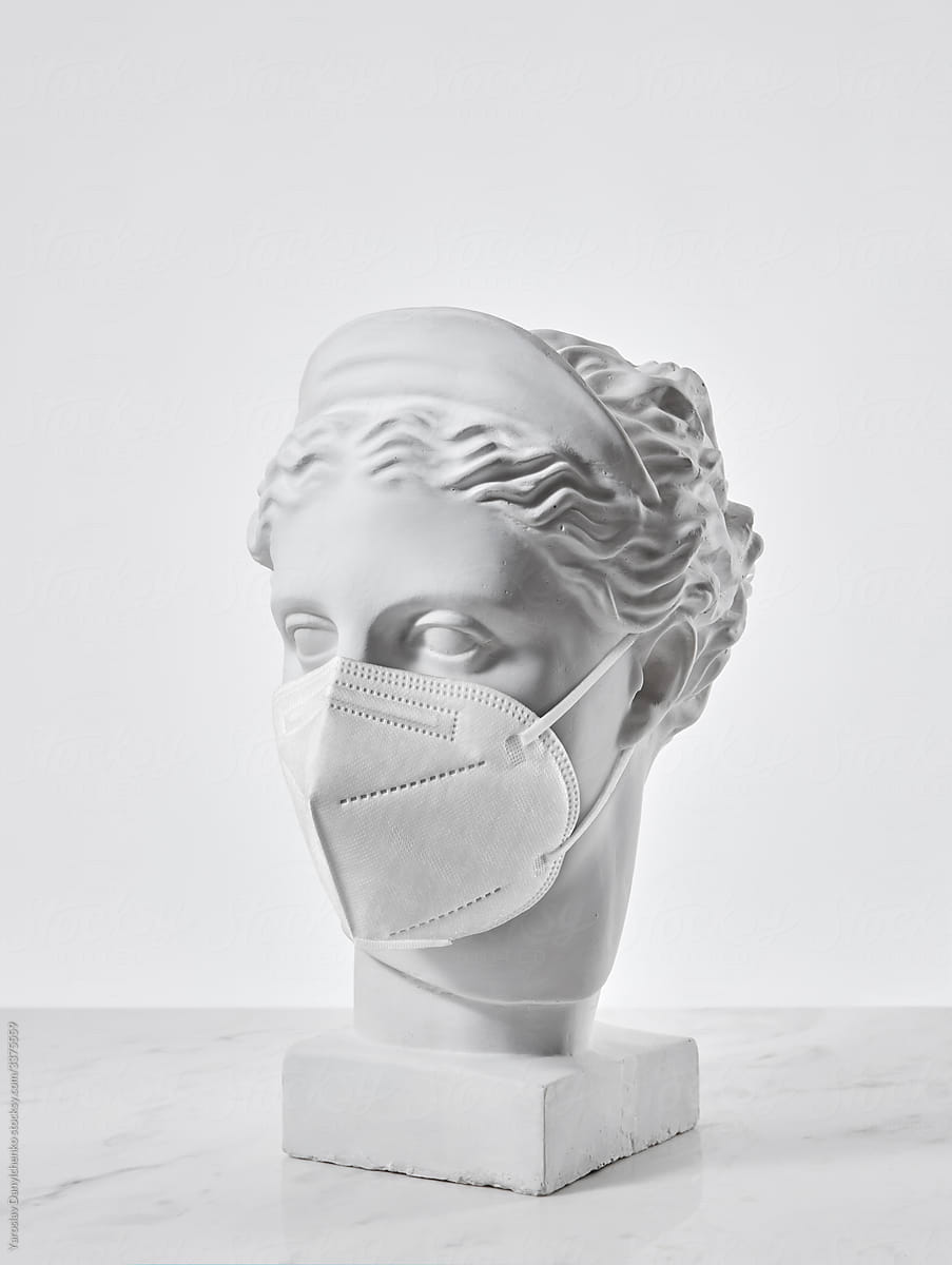 Statue of greek goddess with face respirator.
