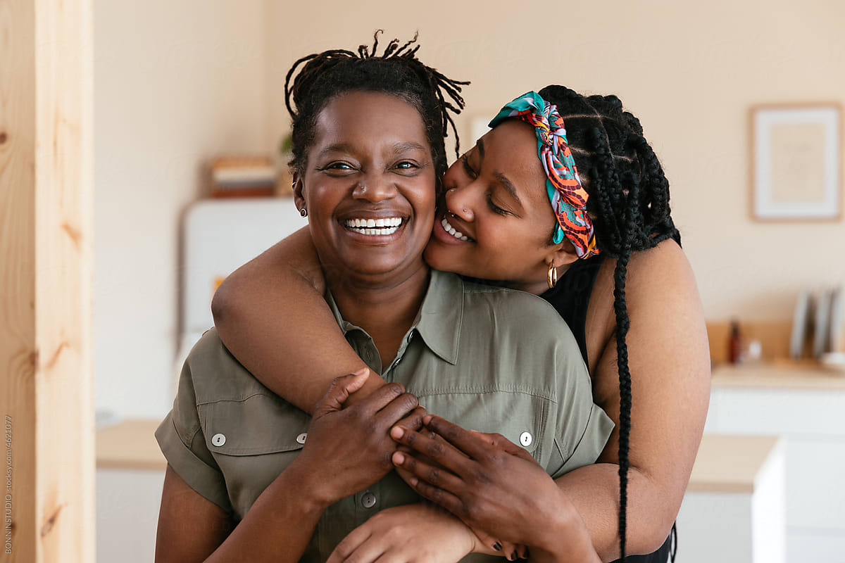 Black daughter hugging happy mother
