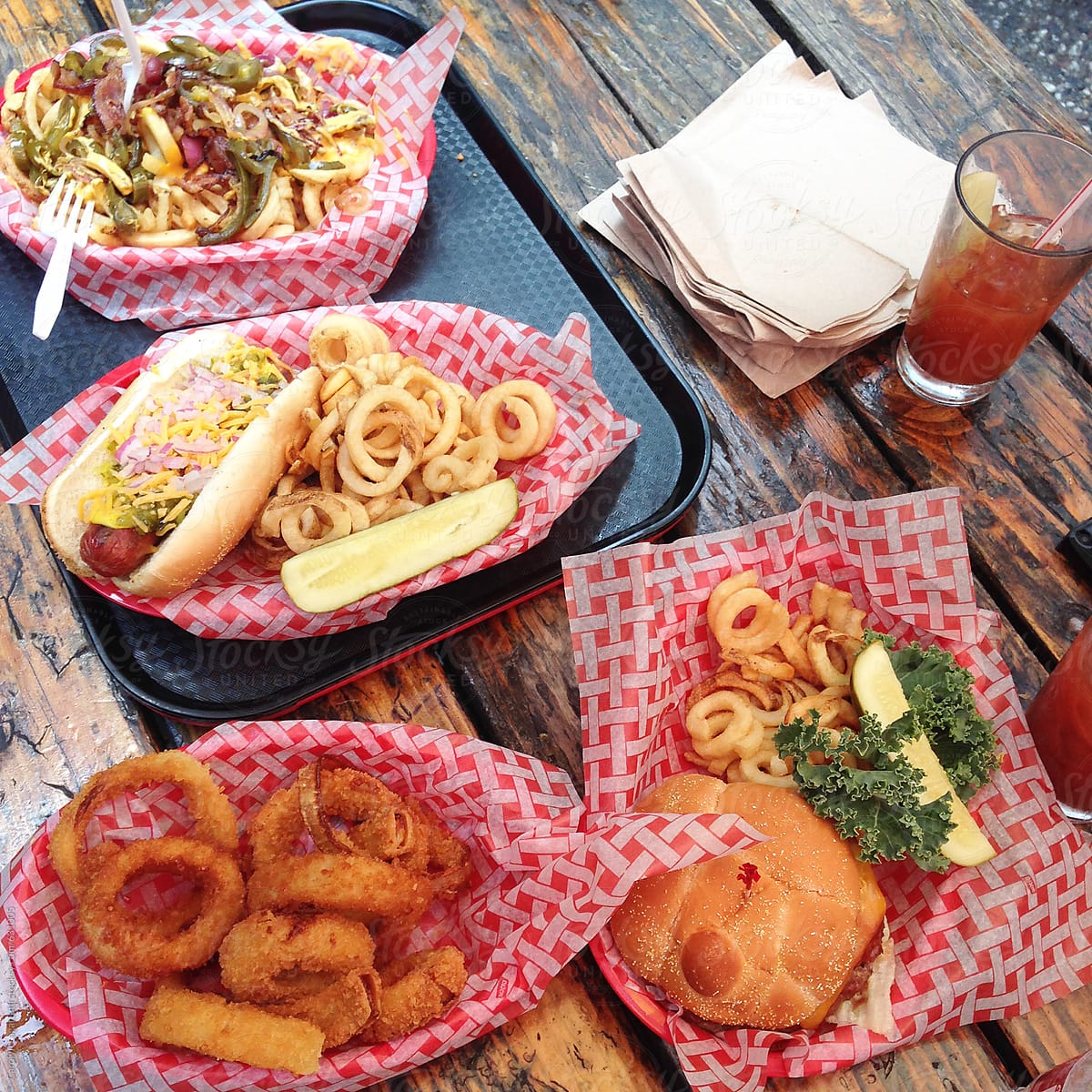 Table with onion rings, hot dogs, hamburgers and other delicious American foods