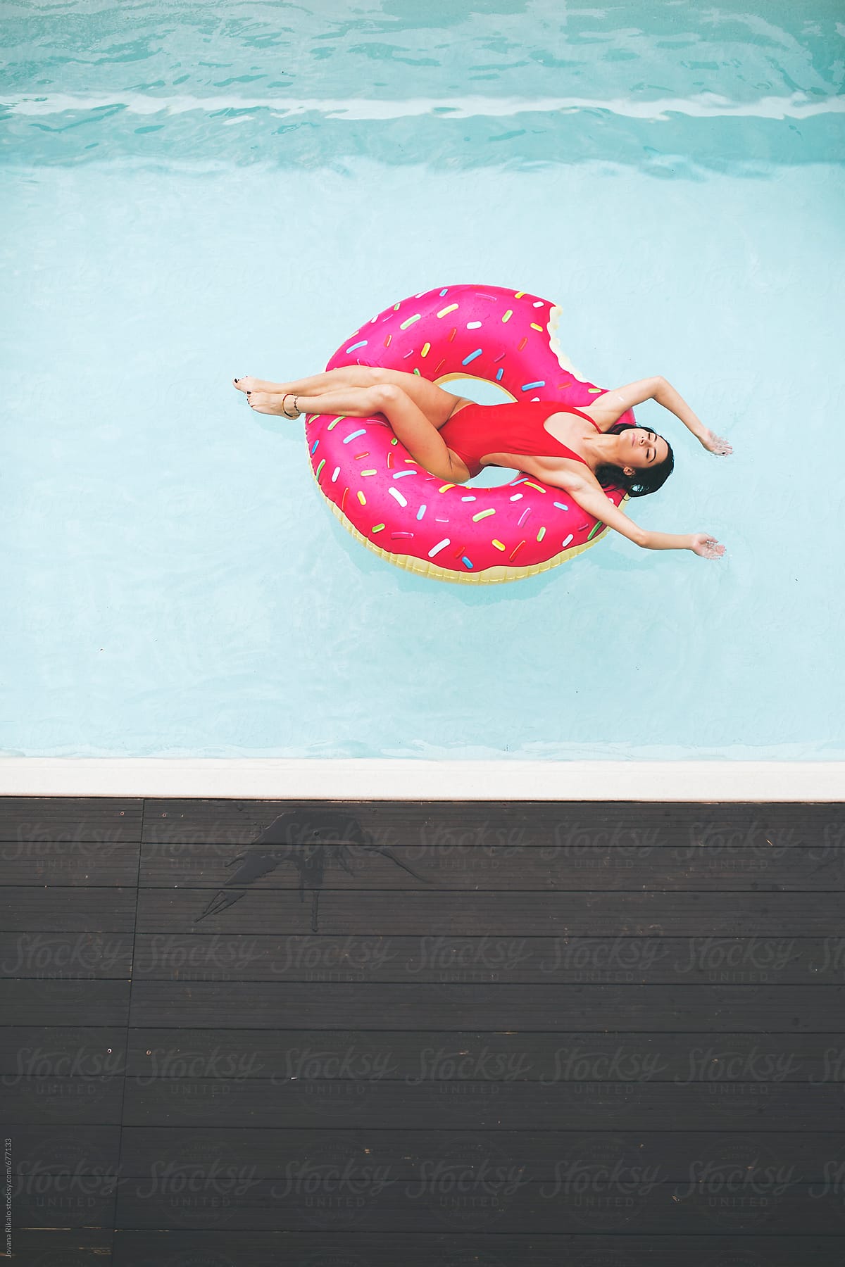 Young Woman Relaxing In A Swimming Pool Del Colaborador De Stocksy