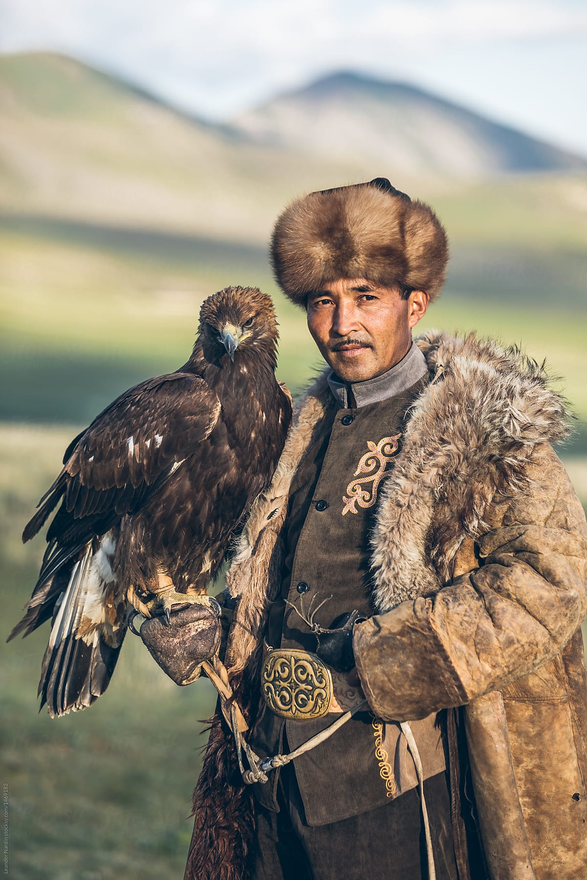 proud kyrgyz eagle hunter with his golden eagle in kyrgyz steppe