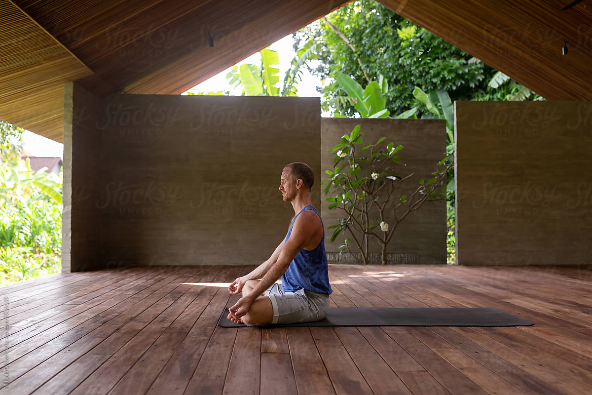 Adult man meditating in yoga studio
