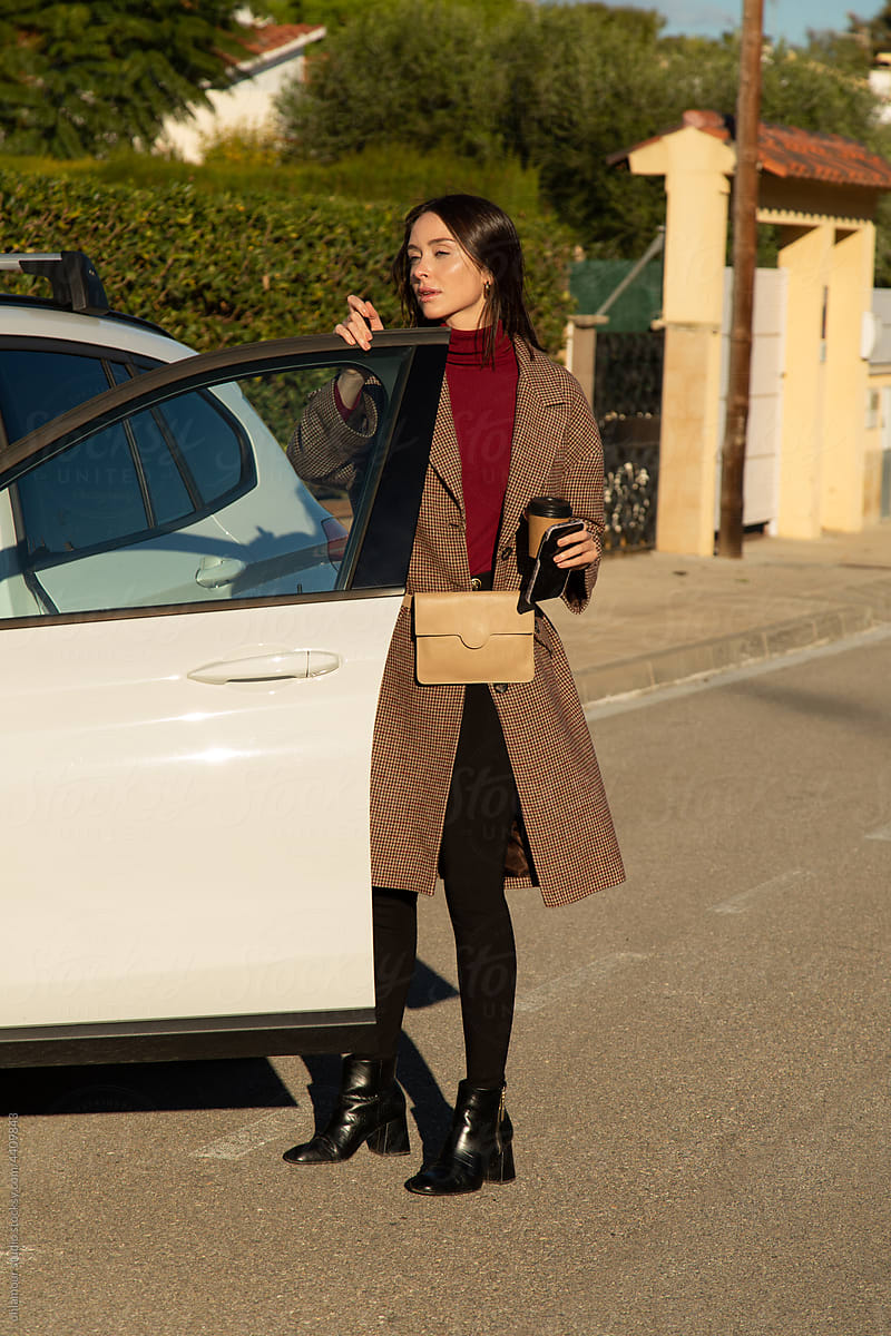 A stylish woman closed the door of her car