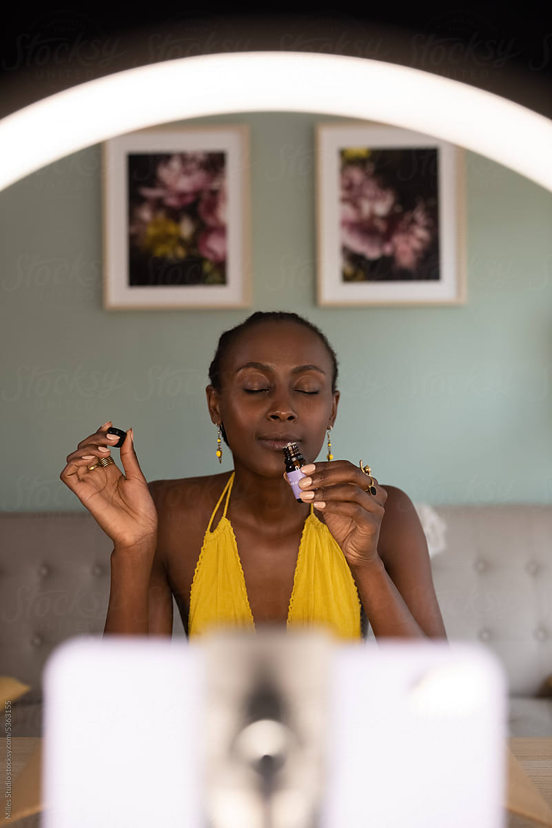 Black female content creator smelling aromatic oil