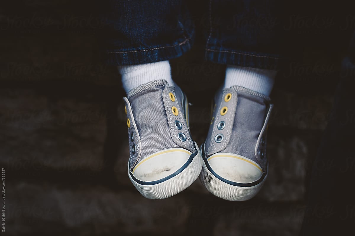 Feet of a child wearing grey tennis shoes