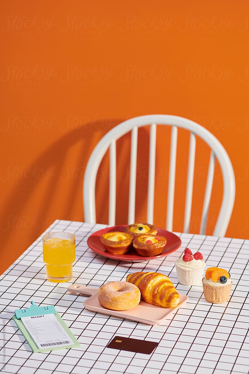 Orange juice and fresh croissants on table with bill and credit card