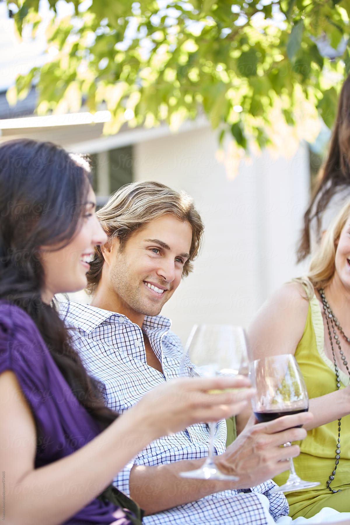 Group of friends drinking wine together outdoors