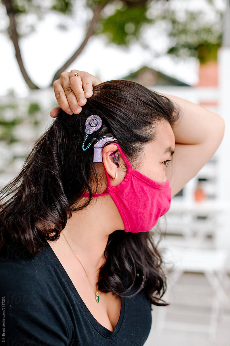 Woman in red mask with cochlear implant