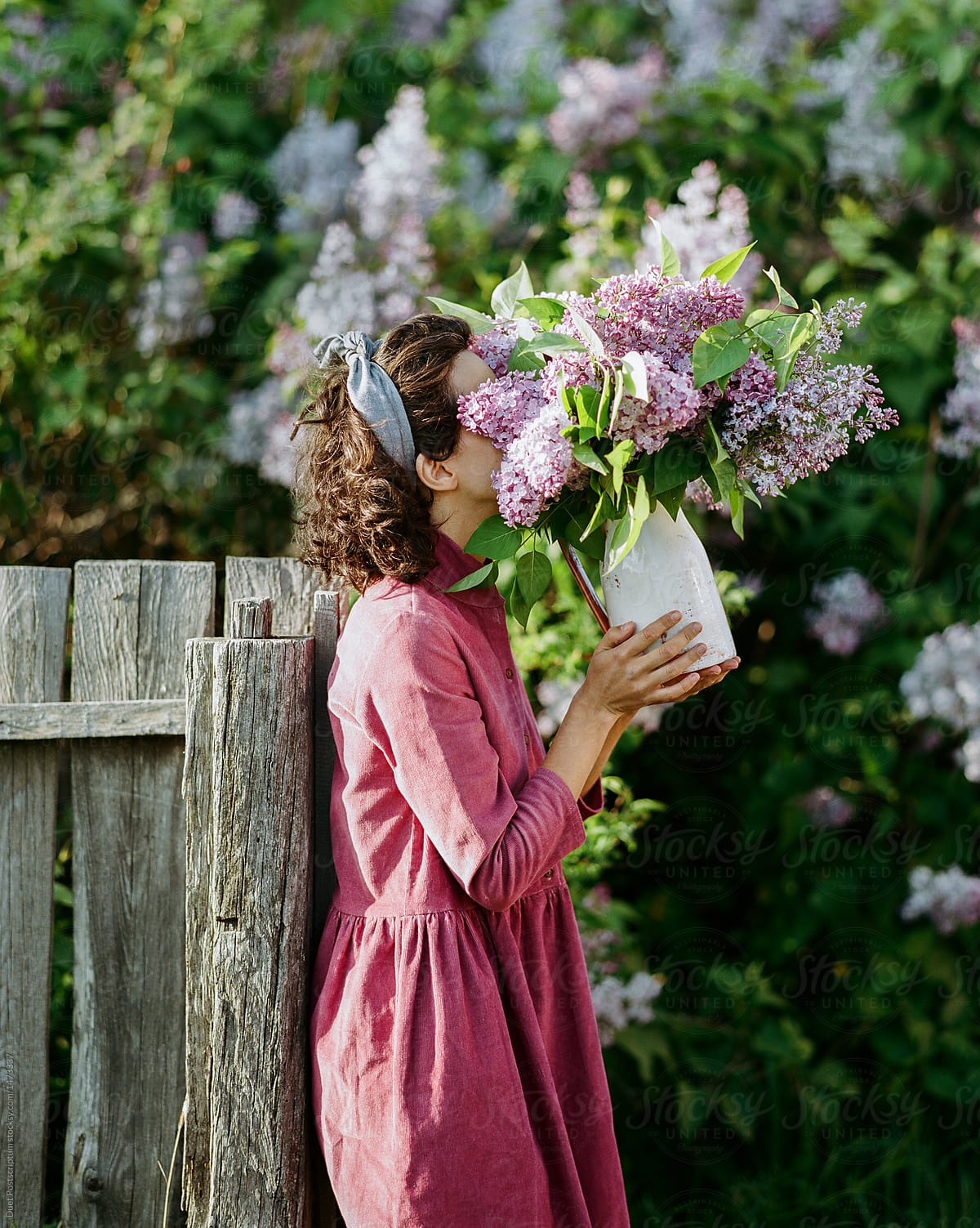 Woman sniffing flowers at fence