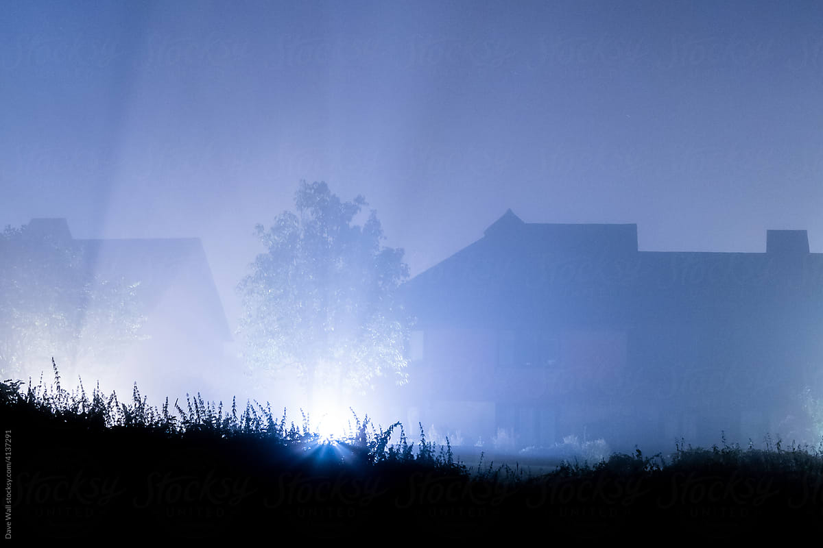 Houses silhouetted on a foggy night