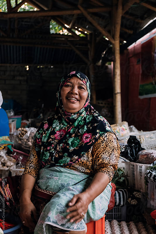 Indonesian old woman selling fruits and vegetables in local market
