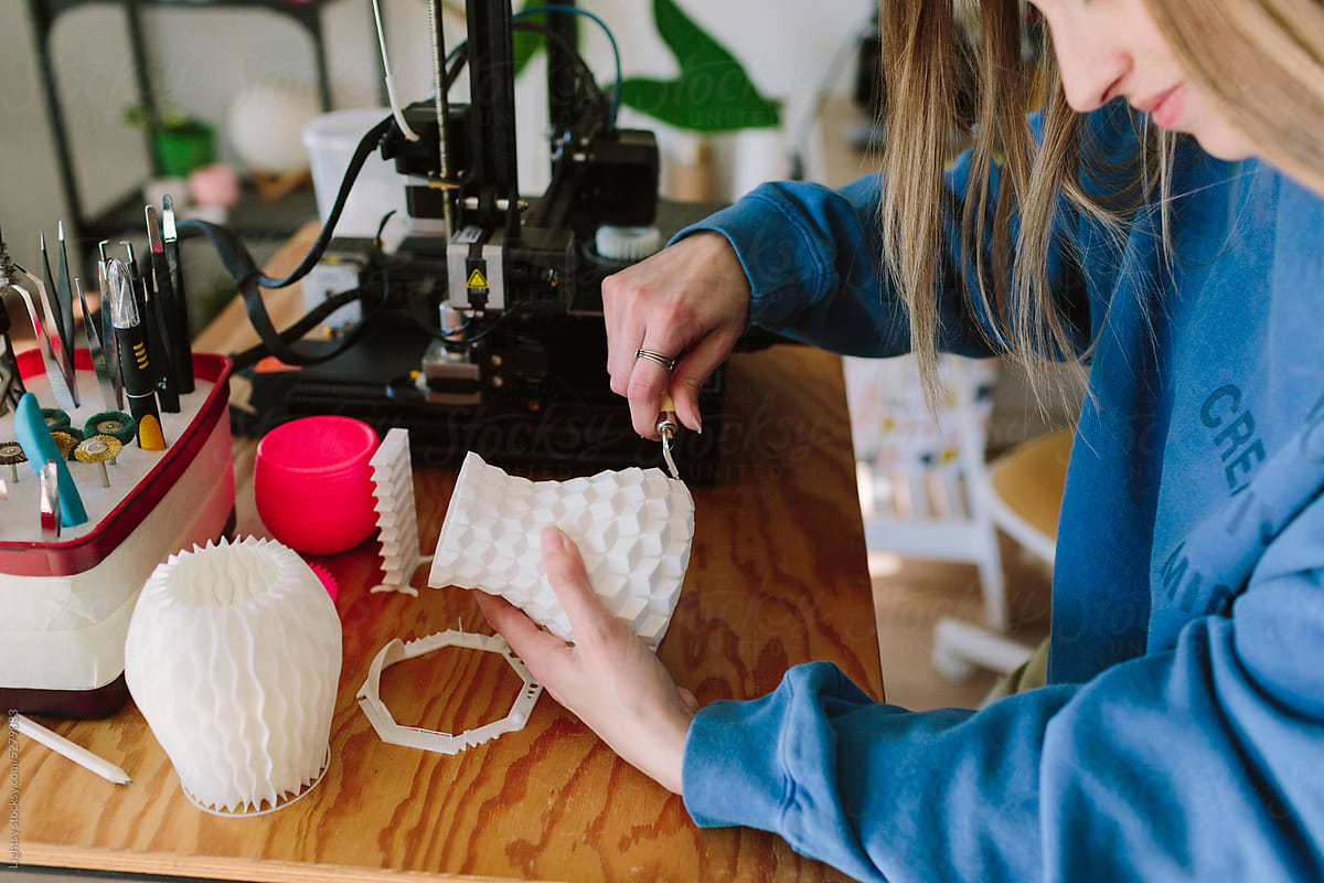 A woman curates a 3D-printed vase